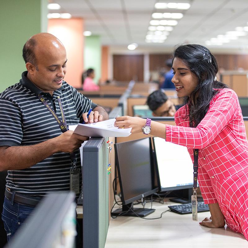 Two upsers review a document together in an office setting