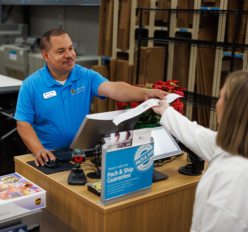 An employee at The UPS Store helping a customer make a box-free, label-free return.