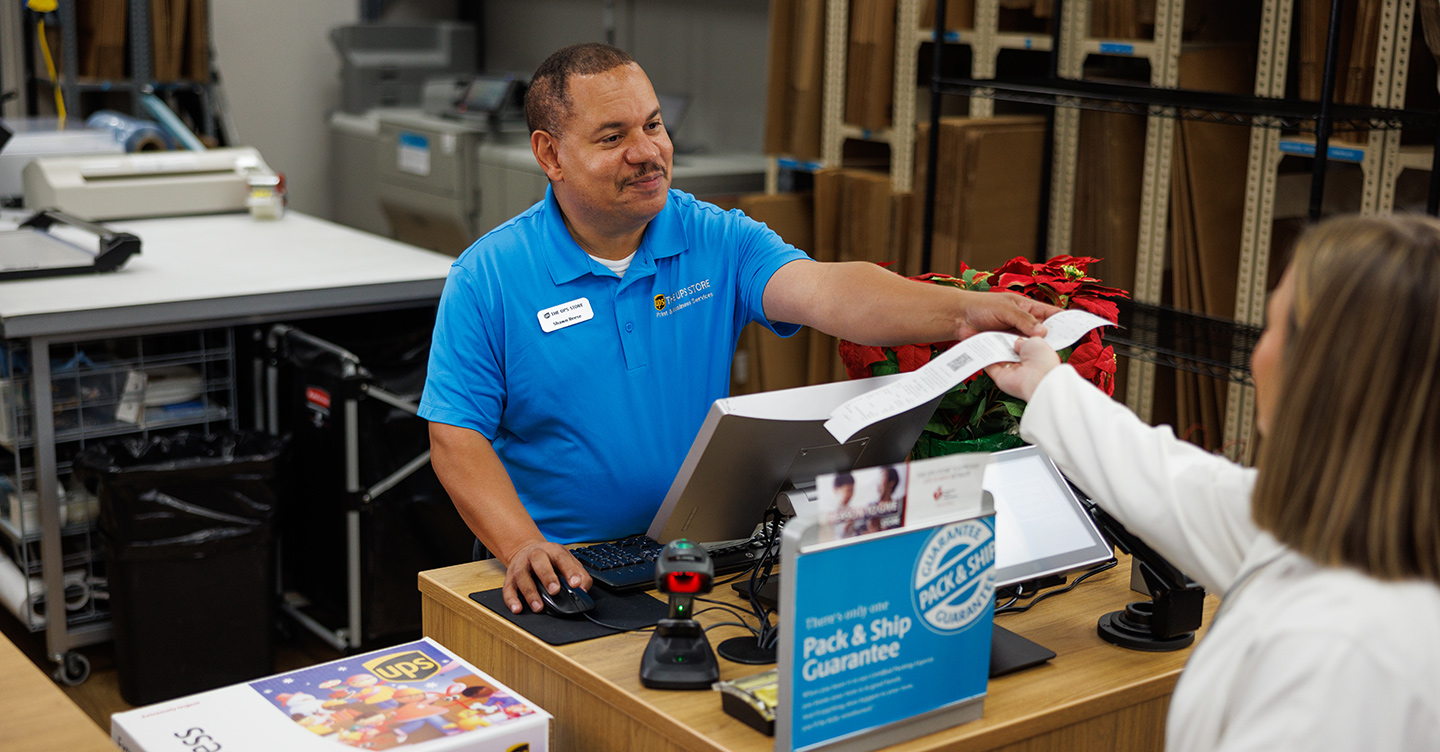 An employee at The UPS Store helping a customer make a box-free, label-free return.