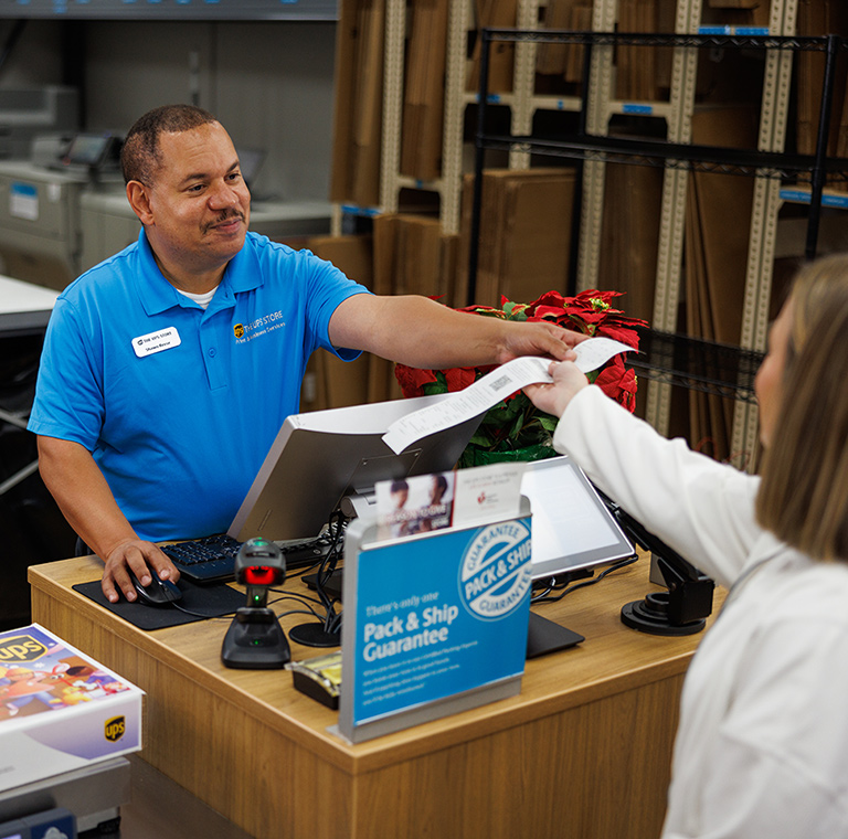 An employee at The UPS Store helping a customer make a box-free, label-free return.